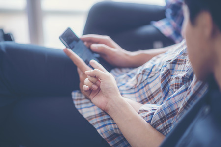 Closeup Group Adult Hipsters Friends Sitting Sofa Using Hands Modern Smartphone Tablet.Business Startup Friendship Teamwork Concept.People Working Together Project.Coworking Process Studioの写真素材