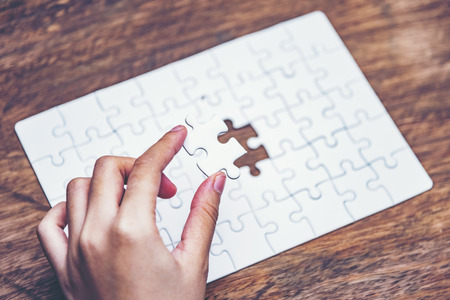 Business solutions, success and strategy concept. Businessman hand connecting jigsaw puzzle.の写真素材