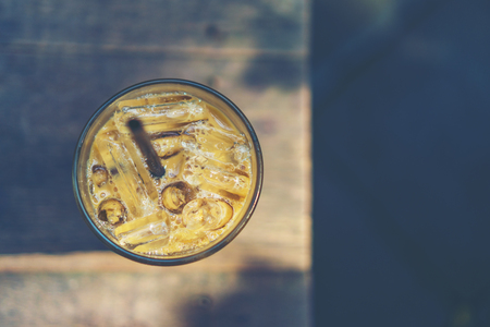 ice coffee glass on wooden table in the cafeの写真素材