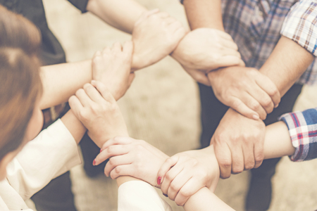 Group of business people crossed arms in pile for win. Stack of hands. Cooperation concept