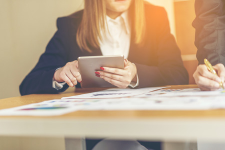 Two analysts discussing online data in front of laptopの写真素材