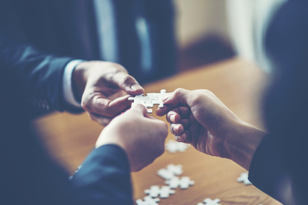 hands trying to connect couple puzzle piece with background, one part of whole. symbol of...
