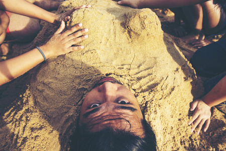 Man buried in the sand at the beach. concept happiness, vacation, no problem, everything is fine.の写真素材