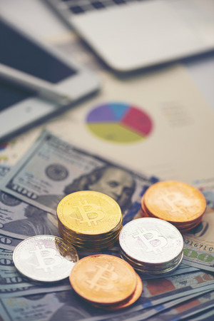 Physical version of Bitcoin (new virtual money) and banknotes of one dollar. Exchange bitcoin for a dollar. Conceptual image for worldwide cryptocurrency and digital payment system.の写真素材