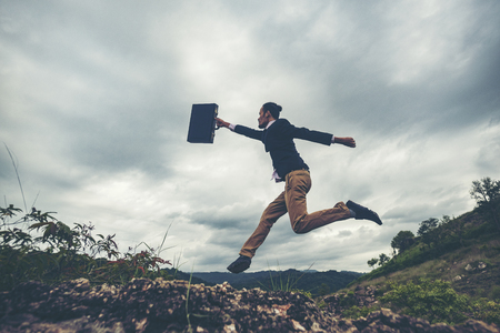 businessman jumping over the mountain, business worker conceptの写真素材