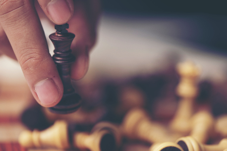 hand of businessman moving chess figure in competition success play. strategy, management or leadership conceptの写真素材