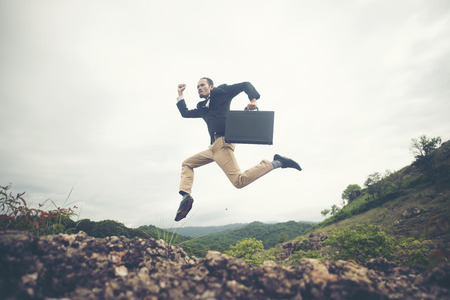 Cheerful Business Man Jumping and Shouting, Successful Corporate People Yelling and Celebrating Joy of Success on Mountain Peakの写真素材