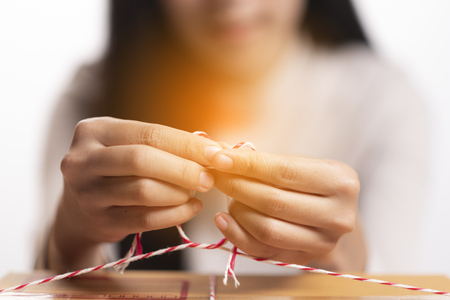 Closeup hand Young asian teenager owner business woman tying a rope preparing package the product with office equipment online shopping, entrepreneur and alpha generation life style conceptの写真素材