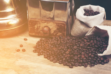 Vintage coffee grinder and beans on wooden backgroundの写真素材