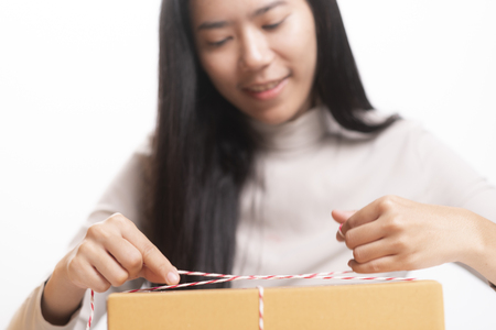 Happy businesswoman receiving a package sitting on a desk at officeの写真素材