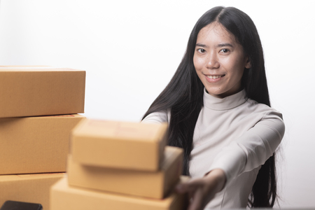 Girl's hands holding the package on the tableの写真素材