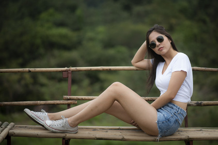 Portrait of a beautiful girl in a field at sunset in summerの写真素材