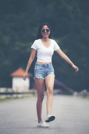 Summer girl portrait. Asian woman smiling happy on sunny summer or spring day outside in parkの写真素材
