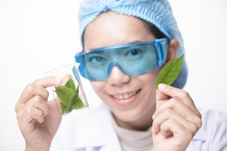 Scientist hand holding green leaf in glass cuvette on laboratory. biotechnology concept.の写真素材