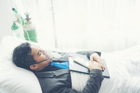 sick businessman still has to work on his own. Business concept, hard workの写真素材