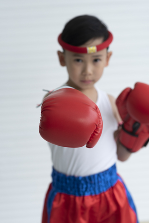 Portrait of young boy boxer in red boxing glovesの写真素材