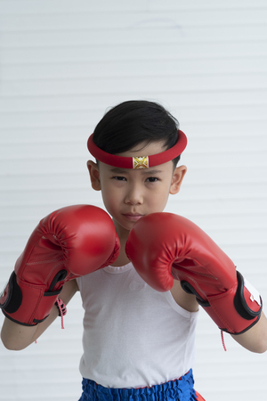 Portrait of young boy boxer in red boxing glovesの写真素材