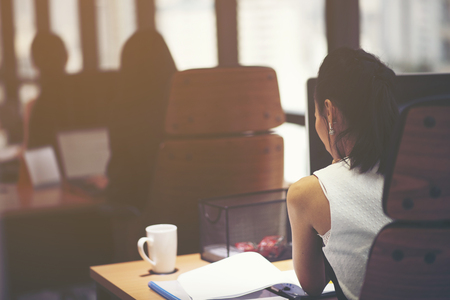 Startup team at work. Big open space office, laptops and paperwork. Business concept. Film effect and lens flare effect, blurry backgroundの写真素材