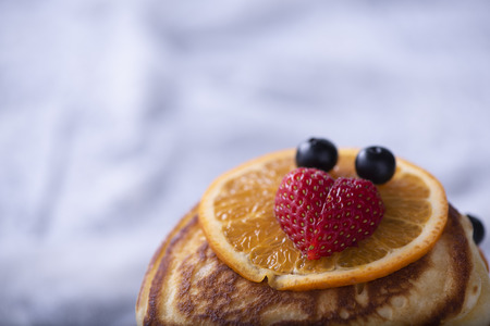pancake stack with strawberry, blueberry, and orangeの写真素材