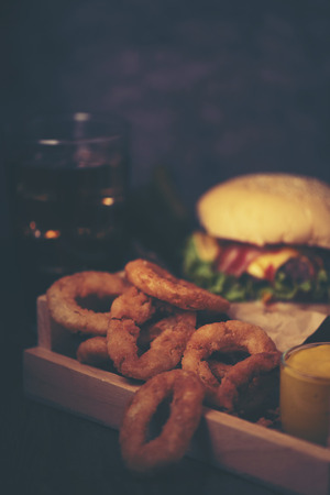 A delicious grilled Angus burger with cheese, lettuce, and tomato on a sesame seed bunの写真素材