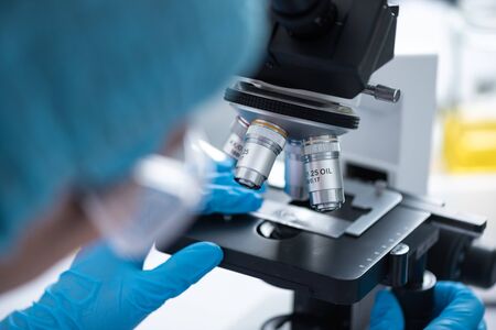 Scientists are using microscopes. For laboratory experiments