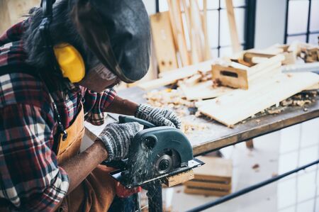 Carpenter working on woodworking machines in carpentry shop. woman works in a carpentry shop.の写真素材