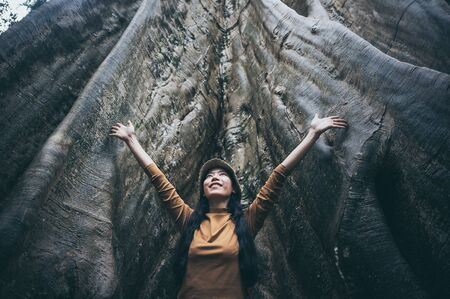 Asian women and big tree, nature connecting conceptの写真素材