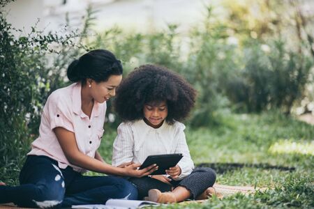 Mother is teaching daughter's homework through Tabletの写真素材