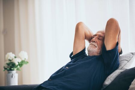 The old man is relaxing on the sofaの写真素材