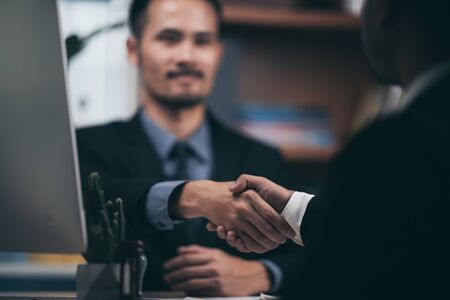 Two confident business man shaking hands during a meeting in the office, success, dealing, greeting and partner concept.の写真素材