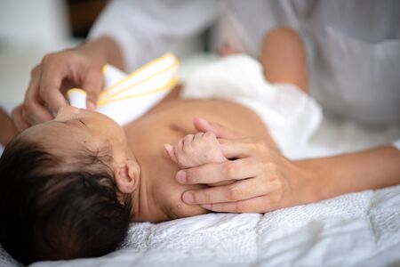 Asian parent hands holding newborn baby fingers, Close up mother's hand holding their new born baby. Love family healthcare and medicalの写真素材
