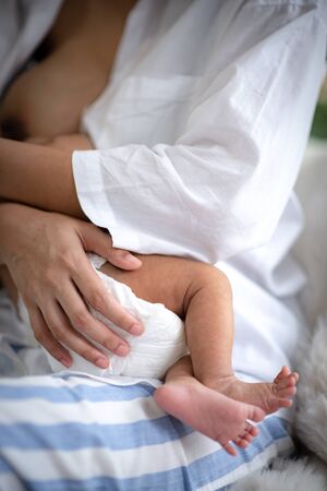 Asian parent hands holding newborn baby fingers, Close up mother's hand holding their new born baby....