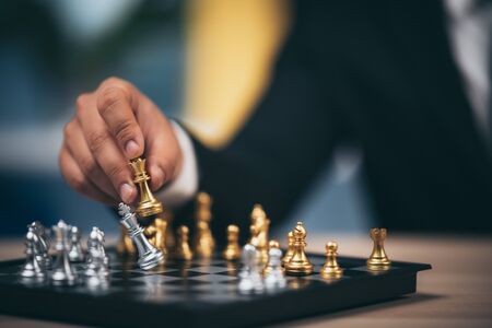 Close up shot golden chess to defeat killing silver king chess on white and black chess board for...