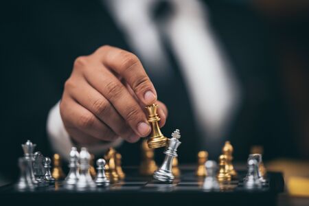 Close up shot golden chess to defeat killing silver king chess on white and black chess board for...