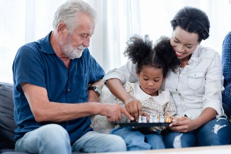 A happy family, grandfather, father, mother and daughter.