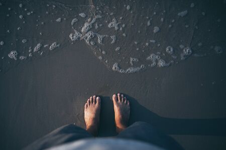 Feet on sea sand and wave, Vacation on ocean beach, Summer holiday.