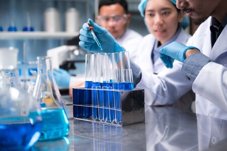 asian scientist hold a test tube filled with liquid in the laboratory