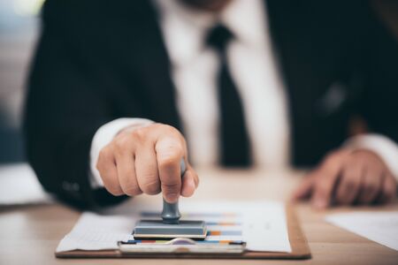 Young business man appoval stamper stamp on paper business contract, loan money approved.の写真素材