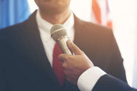 Image of a microphone interviewing an executive wearing a suitの写真素材