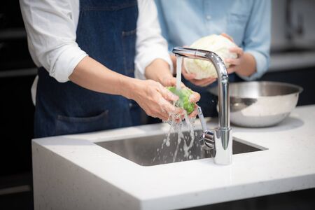 Picture of washing vegetables with water in the kitchenの写真素材