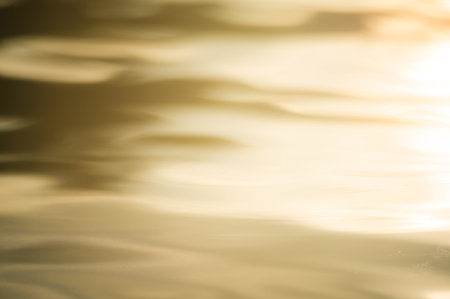 abstract blurry background if golden water surface at sunsetの写真素材