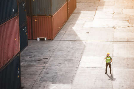 professional foreman person or engineer working on industry construction site with container...