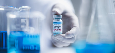 fight against COVID-19, coronavirus vaccine research in hospital laboratory, professional scientists holds bottle of new vaccine for virus cure treatment injection, medicine clinical during pandemicの写真素材