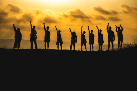 The silhouette of a business network group of business people shaking hands to express the joy and...