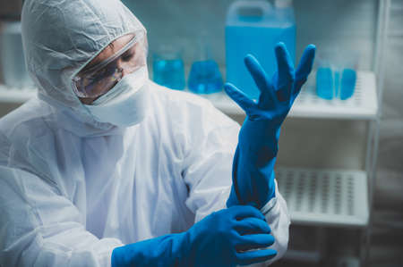 medicine specialist wearing PPE suit setting, medical people wearing surgical glove, face mask, and goggle to protection to work with coronavirus flu in hospital laboratoryの写真素材