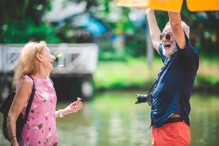 senior old couple celebration for Valentine's Day at Amusement theme park enjoying freedom relaxing, grandmother and grandfather smiling and fun, time to date and marriedの写真素材