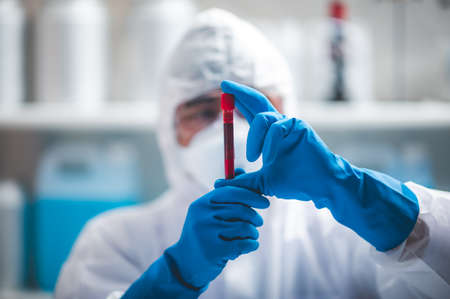 coronavirus covid-19 blood test concept, 2019-nCoV virus checking in medical laboratory with blood test tubes, researcher holding blood sample for testing in hospital labの写真素材