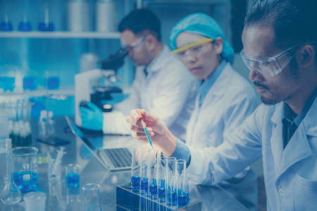 medical science technology research in chemical laboratory, professional scientist working for experiment test in healthcare medicine work with glassware equipment and blue liquidの写真素材