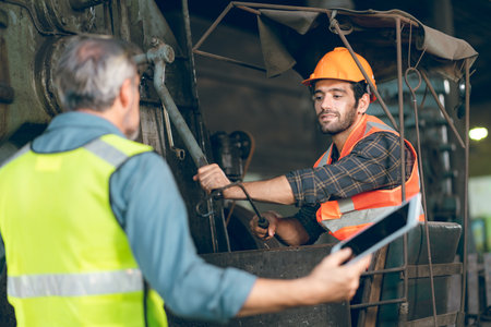 professional technician engineer with safety helmet hard hat working in industrial manufacturing factory, men at work to checking equipment of machinery production technology or construction operatingの写真素材