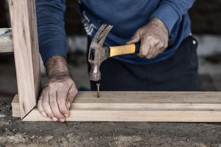 Builder\'s hands hammering nail